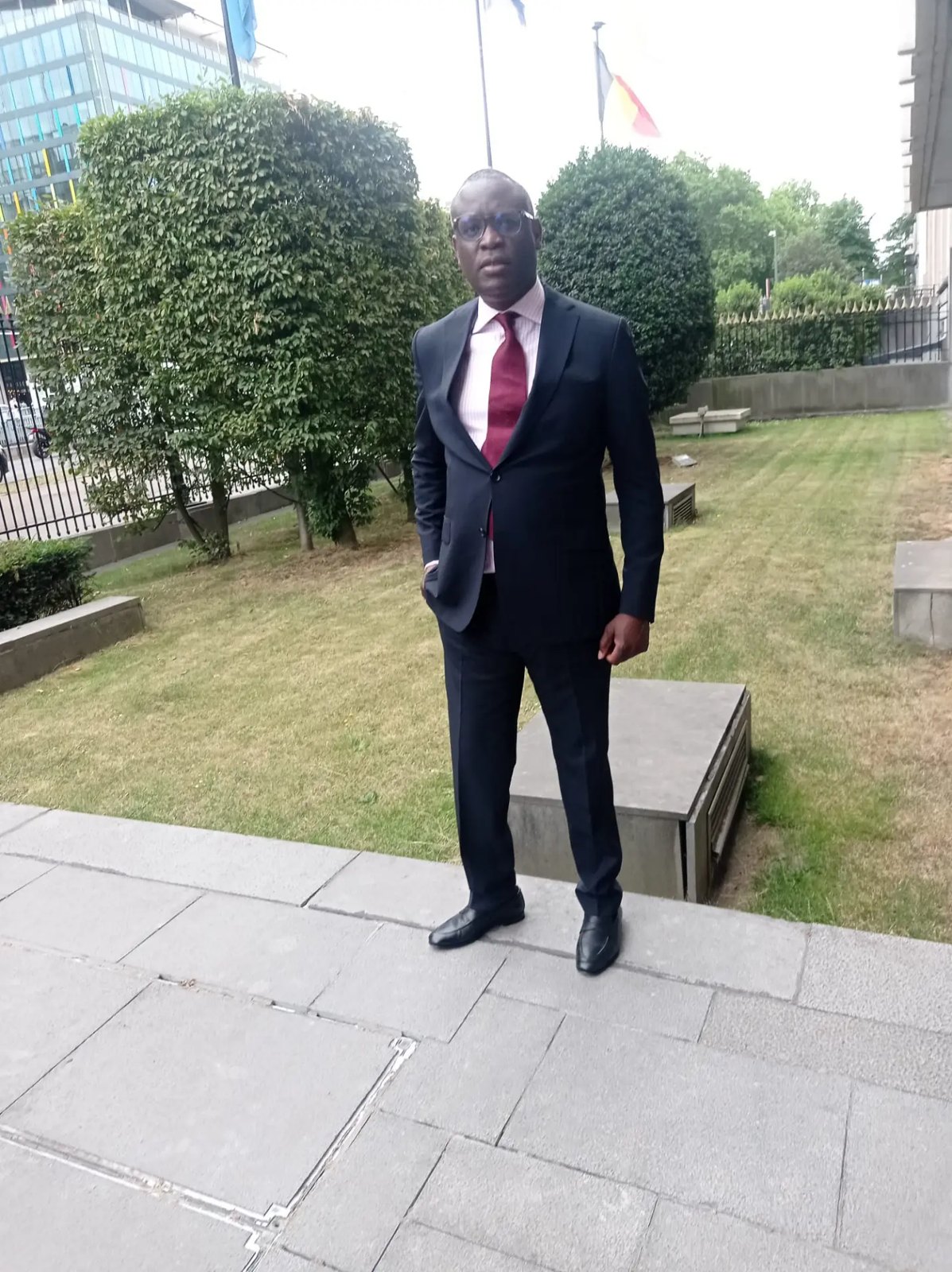 Francis Kibangu devant l'entrée du Bureau des Nations Unies à Bruxelles